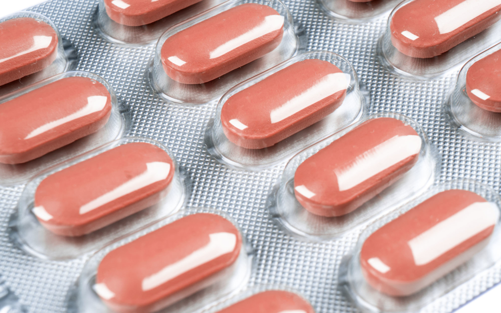 Close up view of red-coated tablets in a blister pack