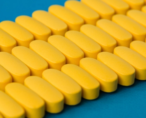 Close up view of yellow-coated tablets in rows