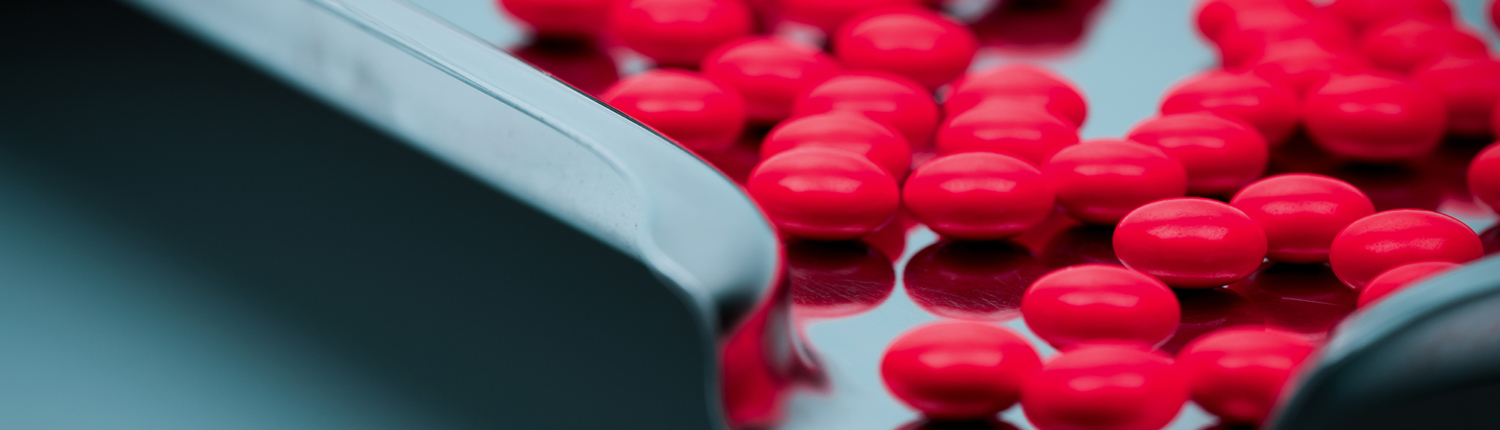 VIew of red-coated tablets in a perforated coating pan